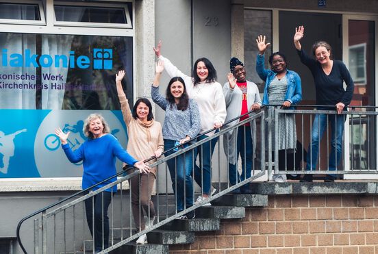 Gruppen von Frauen unterschiedlicher Herkunft auf der Treppe vor einem Gebäude
