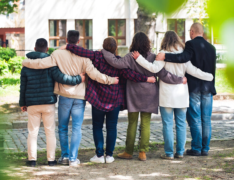 Kleine Gruppe aus Männern und Frauen bilden eine Menschenkette.