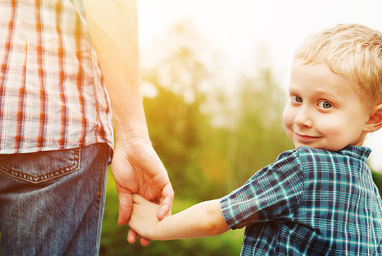 Erziehungsberatung, Junge hält die Hand seines Vaters