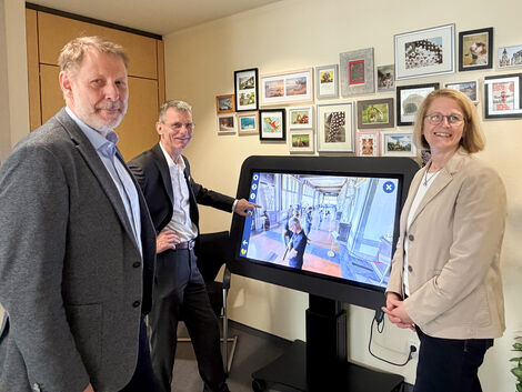 Zwei Männer und eine Frau stehen neben dem CareTable